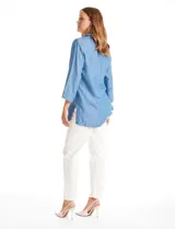 Blusa de lyocell color azul, con cuello camisero, escote en V con cierre de botones y mangas tres cuartos amplias. Presenta un corte holgado con tajos laterales en el ruedo.