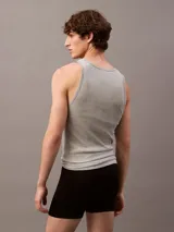 Pack de tres musculosas de algodón puro con cuello redondo y diseño sin mangas. Cada prenda presenta un corte clásico y un pequeño logo monograma bordado en el dobladillo inferior.