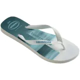 Ojotas Havaianas con base blanca y celeste con diseño de olas, tiras blancas con diseño en relieve y logo de la marca en la base.