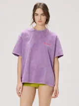 Remera oversize de corte cuadrado, color lila con efecto acid wash, cuello redondo y pequeño gráfico frontal en color rojo.