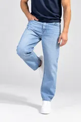 Pantalón jean de corte comfy color celeste claro, con tiro medio, diseño de pierna recta y holgada, con bolsillos laterales y traseros tradicionales.