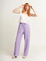 Pantalón de lino color lila, tiro alto, corte palazzo con elástico en la pretina, bolsillos laterales y dobladillo invisible.
