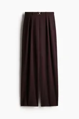 Pantalón sastre color borgoña, de tiro alto con cintura elástica y cinturón decorativo con hebilla dorada. Piernas amplias rectas.