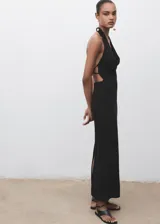 Vestido largo negro de corte entallado con cuello drapeado y espalda descubierta. Presenta un diseño sin mangas y una abertura trasera en el bajo.