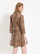 Vestido corto de gabardina con estampado animal print, corte entallado en la parte superior y falda tableada.