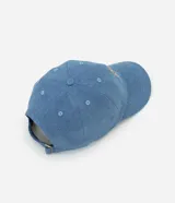 Gorra de jean celeste con visera curva y bordado de un oso en el frente.