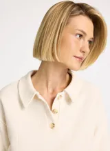 Chomba color crudo de tejido acanalado, corte holgado, cuello camisero, mangas cortas y anchas, bajo recto y caída estructurada.