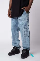Pantalón tipo cargo de denim con lavado ácido, corte holgado y bolsillos laterales con solapa.