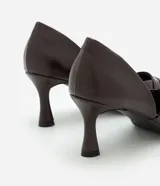 Zapato de tacón medio con diseño de recorte lateral, punta fina y detalle de pliegues en la parte delantera. Confeccionado en poliuretano con acabado liso.