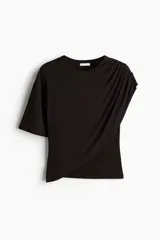 Top de manga corta y punto suave color negro, con escote redondo y panel drapeado frontal que genera un diseño asimétrico.