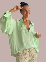 Camisa verde lima de viscosa con cuello clásico, mangas largas abullonadas y puños con botón.