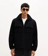 Campera tipo trucker de tejido polivelour, con cuello camisero, cierre frontal por cremallera y dos bolsillos frontales con solapa en el pecho.