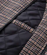 Campera masculina de corte regular con estampado a cuadros, cierre frontal con cremallera y capucha fija con borde de pelo sintético. Cuenta con bolsillos frontales con solapa y cierre de botón a presión.