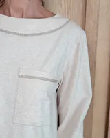 Remera de manga larga color marrón chocolate, con cuello redondo y dos bolsillos frontales tipo parche.