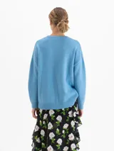 Sweater de punto con textura suave, de silueta relajada y largo por debajo de la cadera. Presenta cuello redondo, mangas largas y costuras laterales desplazadas hacia el frente.