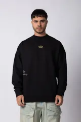 Buzo de cuello redondo y corte oversize, confeccionado en frisa suave. Presenta un diseño minimalista en color negro con un pequeño logo ovalado en el centro del pecho y una estampa sutil en el lateral inferior derecho.