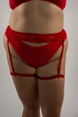 Portaligas fino de color rojo, confeccionado en puntilla elastizada con tiras ajustables para las piernas y broche en la parte trasera.