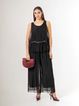 Pantalón de seda italiana con forro de viscosa elastizada, de corte holgado y diseño fluido, con detalles de paillettes en los costados y cintura elastizada.