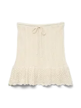 Pollera corta tejida en punto calado, color beige, con tiro medio, cintura elástica con cordón ajustable y ruedo con volado.