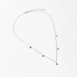 Collar plateado con cadena fina y dijes circulares colgando.