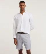 Bermuda slim de lino y algodón color beige, de corte ajustado, con trabillas para cinturón y bolsillos laterales y traseros.