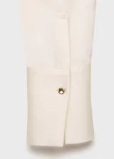 Camisa de corte clásico con acabado satinado, cuello camisero, cierre frontal con botones y manga larga con puños abotonados.