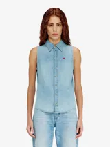 Camisa vaquera sin mangas de Diesel, color azul claro, confeccionada en algodón orgánico. Presenta cierre frontal de botones, cuello camisero, bajo curvado y un pequeño logotipo bordado en el pecho.