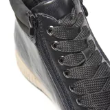 Zapatilla urbana negra de caña alta, con cordones frontales, cierre lateral y suela beige.