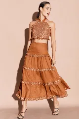 Falda larga de lino color marrón con volados y detalles de brillos en cada nivel.