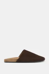 Zapato tipo mule de cuero con suela plana y punta redonda.
