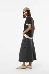 Falda midi cargo de denim color gris con efecto lavado, de corte recto y relajado. Cuenta con bolsillos laterales con tapa, bolsillos traseros y una abertura frontal.