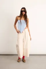 Pañuelo de tejido en hilo de color celeste con bordado artesanal rojo en los bordes, de formato triangular.