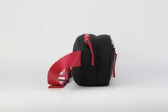 Riñonera negra de nylon con detalles en rojo y logo de la NBA. Tiene doble cierre y correa regulable con estampado del logo de la NBA.