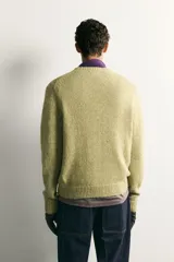 Jersey relaxed fit tejido en hilatura de algodón de color verde, con cuello redondo, manga larga y acabados en rib.