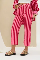 Pantalón de denim de tiro medio con diseño de rayas verticales en tonos rojo y rosado, de corte recto y largo midi.