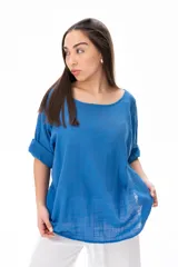 Blusa azul de corte holgado con mangas cortas arremangadas y escote redondo.