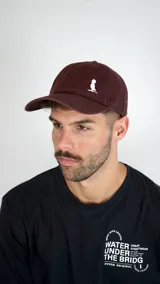 Gorra de béisbol color bordó con logo bordado en blanco en el panel frontal.