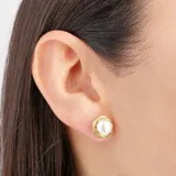 Aros dorados con perla blanca central.