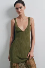 Vestido midi de punto acanalado color verde oliva, con escote en V y tirantes anchos. La parte superior presenta un diseño de tejido rib, mientras que la parte inferior está terminada con una aplicación de encaje transparente al tono.