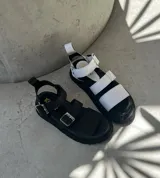 Sandalias de cuero negras con hebillas plateadas y suela gruesa.