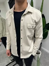 Sobrecamisa de gabardina color beige con cierre frontal de botones metálicos a presión, dos bolsillos frontales con solapa y diseño de canesú estilo western.