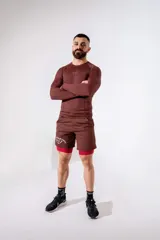 Short deportivo de lycra color marrón, con calza interna integrada en color rojo y estampado lateral en blanco.