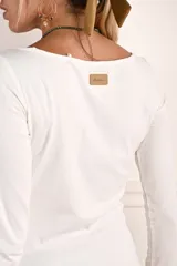 Remera de manga larga ajustada al cuerpo, con cuello redondo, confeccionada en una mezcla de algodón y elastano que aporta suavidad y elasticidad.