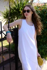 Vestido midi blanco sin mangas, de corte recto y holgado, con detalle de costura diagonal en relieve.