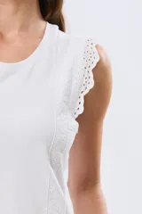 Musculosa de algodón color azul con detalles de broderie calado en los hombros, de cuello redondo y corte clásico.