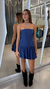 Vestido corto strapless color azul, con falda con volados en el ruedo y diseño ajustado al cuerpo.