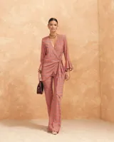 Pantalón acampanado de talle alto con cinturilla de goma en la parte trasera y cremallera lateral, con estampado geométrico en tonos naranja y azul.