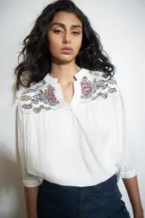 Blusa color crudo con bordado multicolor en los hombros, cuello mao y mangas 3/4.