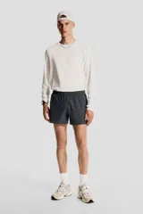 Short de correr gris oscuro, confeccionado en tejido funcional DryMove™ que ayuda a absorber el sudor y mantenerse fresco. Modelo de corte estándar con elástico revestido y cordón para ajustar oculto en la cintura, bolsillos laterales discretos con cierre y suspensor interior en malla suave. Abertura corta en los laterales.