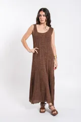 Vestido largo de punto tejido con acabado brillante en tono marrón, sin mangas, con escote redondo y silueta fluida.